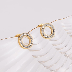 Golden stainless steel hoop earrings with sparkling zircon stones on textured glass