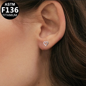 Vista dettagliata del piercing a cuore in titanio ASTM F136 sulla cartilagine