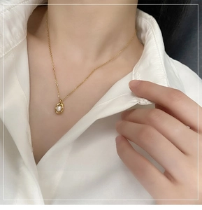 Detail of freshwater pearl necklace with irregular gold setting worn on a neck