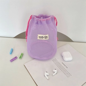 Close-up of purple mesh drawstring pouch storing AirPods and small accessories