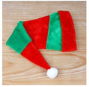 Vue à plat d'un long bonnet de noël rayé rouge et vert en peluche sur une surface en bois