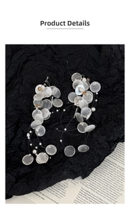 Macro detail of cascading shell discs and white pearls on elegant tassel earrings