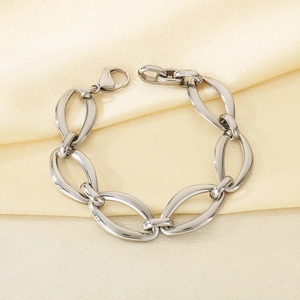 Macro shot of silver oval chain bracelet with lobster clasp on yellow fabric