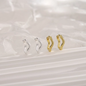 Close-up of gold and silver wavy diamond hoop earrings featuring S925 hallmark