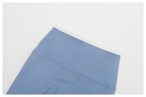 Detail of high-waisted yoga leggings with white contrast binding and flatlock seams