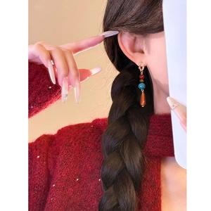 Boucles d'oreilles élégantes avec perles rouges et turquoise sur un modèle au style rétro