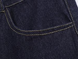 Vue détaillée de la poche en jean bleu foncé avec double couture jaune classique