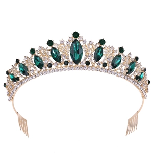 Golden bridal crown with emerald gemstones and sparkling rhinestones on white background