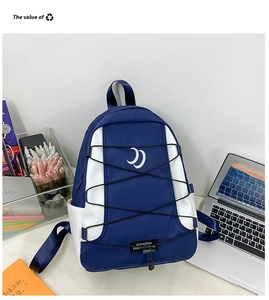 Detail van de blauw-witte rugzak met elastische koorden en geweven merklabel op de tas