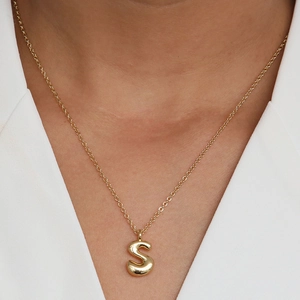 Detail of 18k gold plated bubble initial S pendant on a polished O-chain necklace