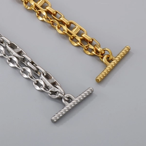 Detailed macro view of dual-tone gold and silver chain bracelet with T-bar toggle clasp
