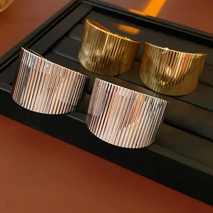 Macro view showing ribbed texture of gold and silver metallic wide cuff bracelets