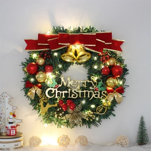Illuminated Christmas wreath with red bows and gold bells for holiday door decoration
