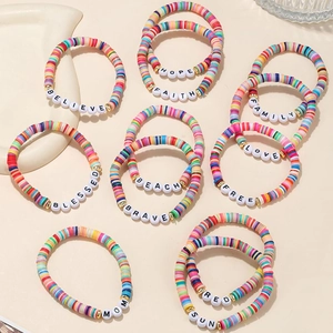 Close-up of 11 colorful clay bead friendship bracelets with assorted letter charms