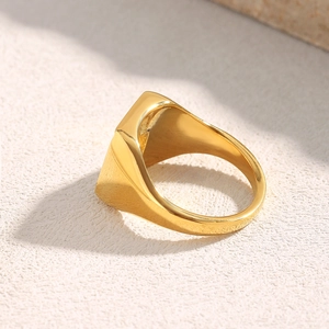 Macro view of gold plated signet ring with geometric facets and polished finish