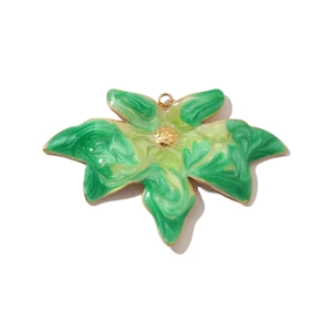 Macro detail of leaf-shaped titanium steel pendant with green marble texture and gold trim