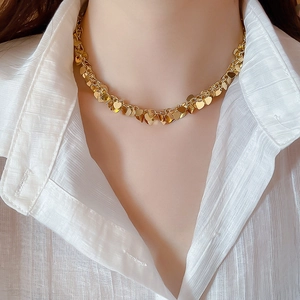 Dettaglio ravvicinato della collana choker dorata con frange a cuore indossata