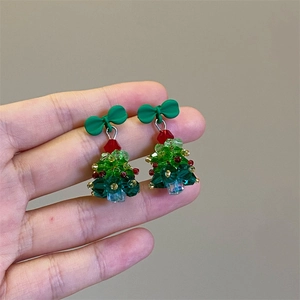 Detailed view of handmade beaded Christmas tree earrings with a festive red ribbon bow