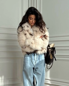 Detail of short faux fur leopard print jacket with large collar and plush texture