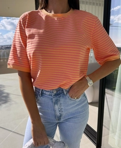 Gros plan du t-shirt en coton à rayures orange et rose avec texture douce et col rond