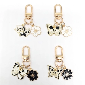 Black and white enamel butterfly and skull keychain set with gold metal finish