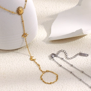 Détails des breloques soleil et étoile en or 18 carats sur un bracelet esclave
