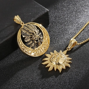 Golden Indian skull and sun face pendant necklaces with box chains on black background