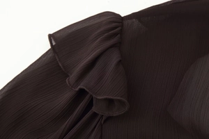 Detailed view of dark coffee pleated chiffon fabric and delicate ruffled edge stitching