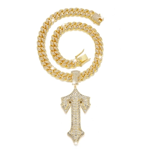 Detailed view of the gold-tone hip hop chain with iced-out T-pendant and clear crystals