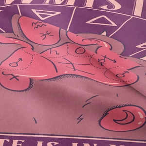Close-up of pink and purple tapestry fabric showing astrology patterns and celestial symbols