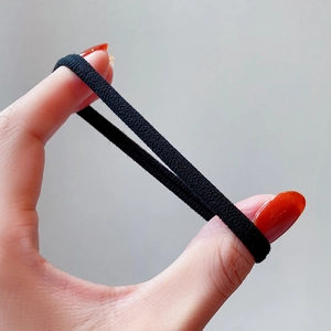 Black seamless high-elastic hair tie shown stretching to demonstrate superior durability