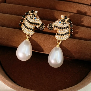 Dettaglio orecchini vintage a zebra con cristalli e gocce di perle bianche