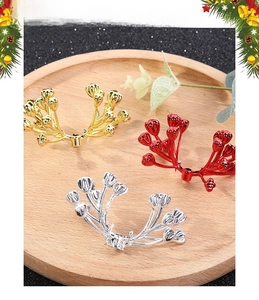 Macro detail of gold, red, and silver festive berries on a rustic wooden tray for Christmas
