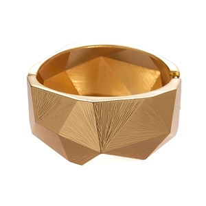 Golden faceted wide bangle featuring radiating textures and geometric minimalist design