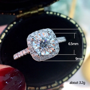 Classic four-prong round halo engagement ring with 6.5mm stone on black velvet display