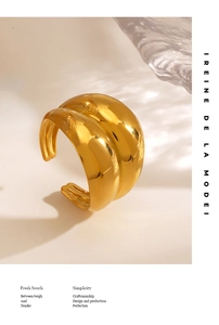 Detail of curved 18K gold plated wide open ring with smooth finish and fluid lines