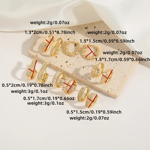 Chic gold hoop earrings set with pearls and zircons on a beige stone display