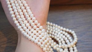 Close-up of S925 sterling silver necklace featuring natural freshwater pearls wrapped on wrist