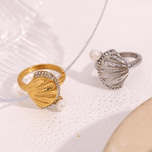 Close-up of gold and silver scallop rings with pearls and sparkling crystal edges