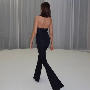 Rear view of sleek black backless jumpsuit featuring slim fit and flared trousers