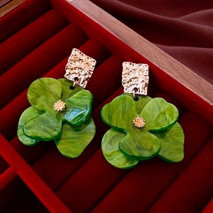 Vintage acrylic flower earrings with gold pleated metal on red velvet box