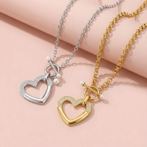 Détail des pendentifs cœurs avec diamants et perles en finitions dorée et argentée