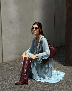 Detail of light blue ruffled maxi skirt paired with brown faux croc leather boots