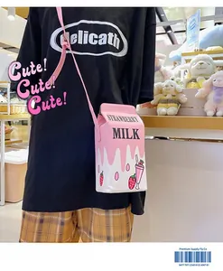 Close-up of strawberry milk carton crossbody bag with pink strap on model