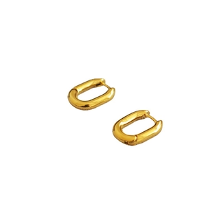 Boucles d'oreilles créoles ovales en forme de U en laiton doré poli sur fond blanc
