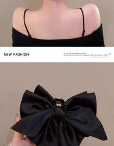 Dettaglio di un grande fermaglio per capelli con fiocco in raso nero per acconciature