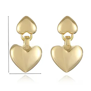 Detailed view of 24K gold-plated double heart drop earrings with high-polish finish