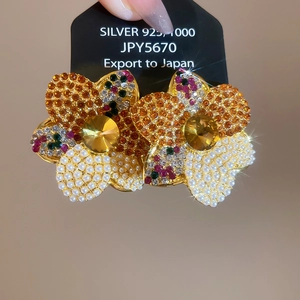 Detailed view of silver 925 floral earrings with colorful rhinestones and white pearls