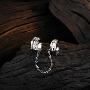 Silver star tassel ear cuff set with chain and crystals on a dark wood background