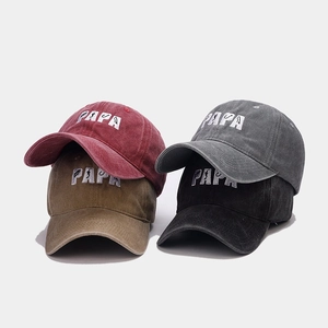 Stack of four washed cotton baseball caps with PAPA fishing embroidery in multiple colors
